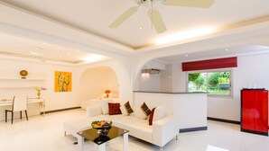 A modern living room with a white sofa, a coffee table, and a red refrigerator. - Serenity Lakeside Resort (Kathu)
