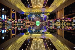 A hotel lobby with a reflective floor, floral arrangements, and a chandelier. - Wansheng International Hotel (Chongqing)