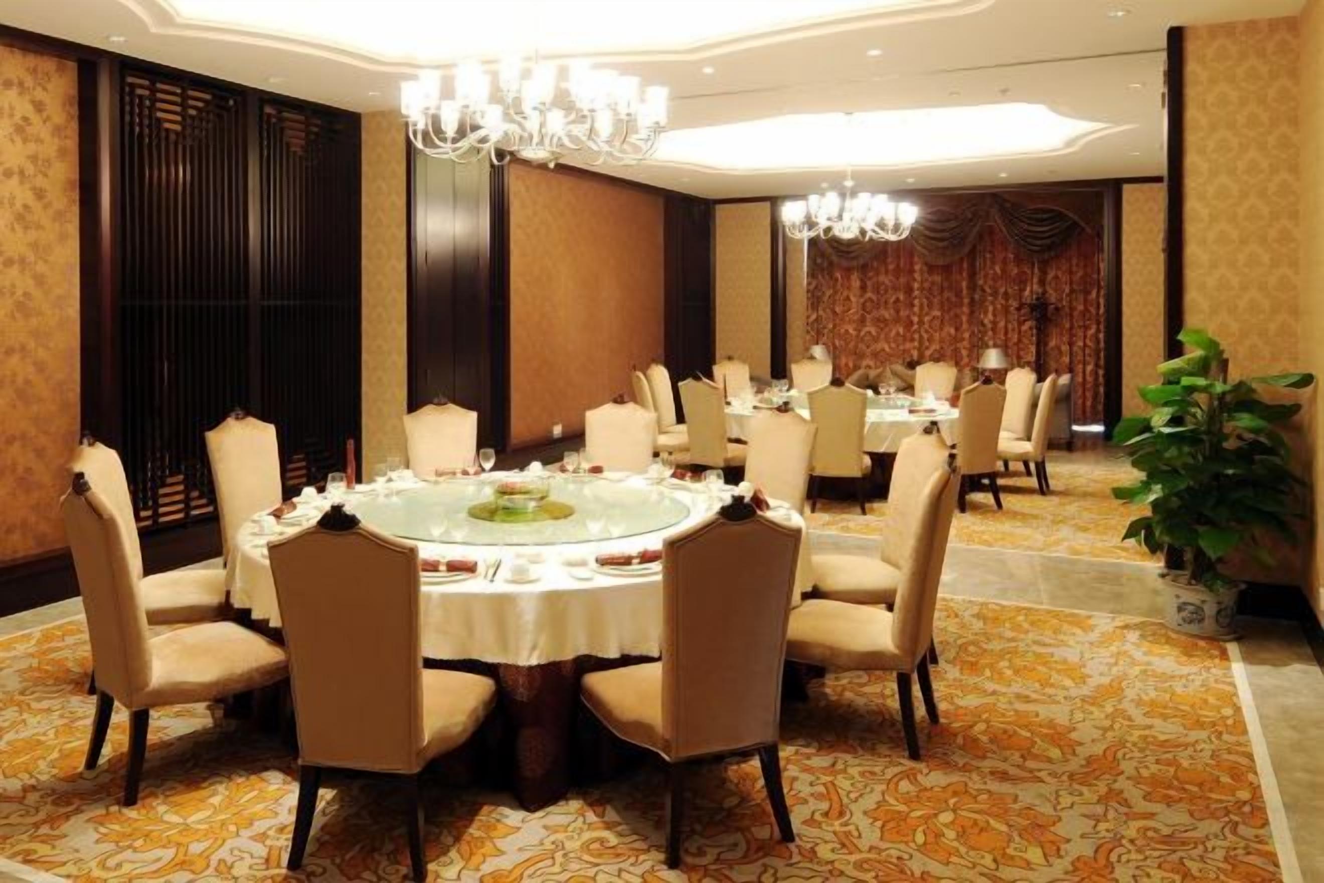 Une salle de conférence équipée d’une table ronde, de chaises et d’un lustre.