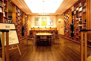 Eine Bibliothek mit Holzbögen, einem zentralen Tisch und einer Chandelier.