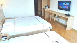 A hotel room with a bed, a desk, a television, and a wardrobe. - Yan'an Grand Hotel (Liuzhou)