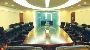 A conference room with a long table, multiple chairs, and a potted plant. - Yan'an Grand Hotel (Liuzhou)