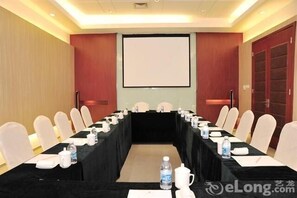 A conference room with a long table, chairs, a projector screen, and a black tablecloth. - Minglan Holiday Hotel (Weihai)