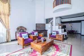 A spacious living room with a fireplace, wooden furniture, and a red patterned rug. - Guilin Landscape Golf Resort (Guilin)