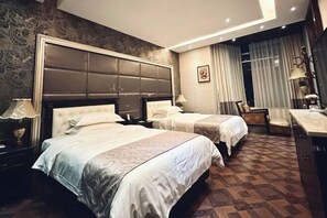 A hotel room with two beds, a desk, a chair, and a large headboard. - Guilin Landscape Golf Resort (Guilin)
