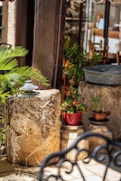 A stone planter with a small fountain and potted plants.