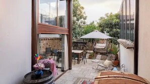 A patio area with outdoor seating, a table, and a large umbrella. - Atelya Art Hotel (Antalya)