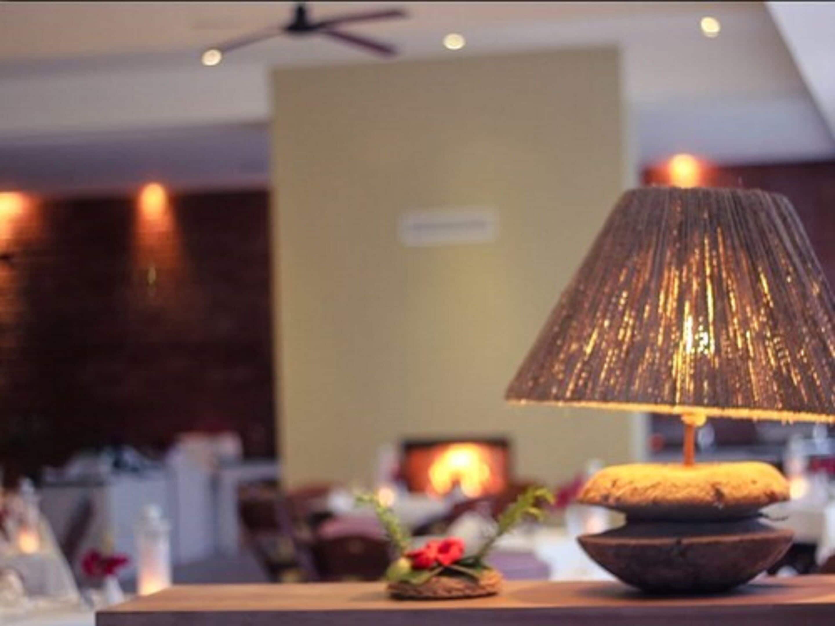 A table with a lamp and a decorative bowl.