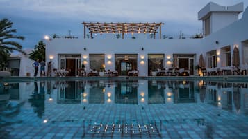 Una piscina al aire libre, sombrillas, tumbonas