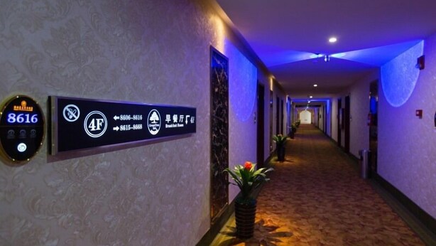 A hotel hallway with directional signs, a digital keycard reader, and a carpeted floor. - GreenTree Inn Nantong Tongzhou District Government  East Bihua Road Business Hotel (Nantong)