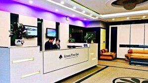 A reception area with a reception desk, a television, and a seating area with a couch and chairs. - GreenTree Inn Nantong Tongzhou District Government  East Bihua Road Business Hotel (Nantong)