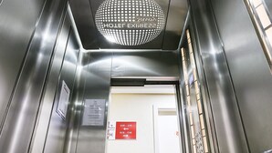 An elevator interior with metallic walls, a digital display, and a sign indicating the direction to the hotel express.