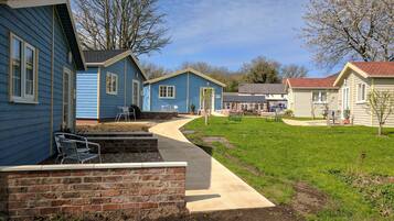 A row of blue and beige cabins with a paved walkway.