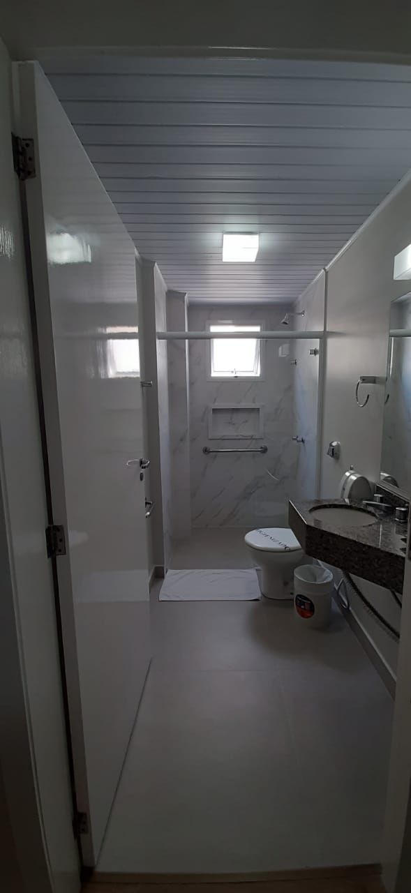 Une salle de bain comprenant des toilettes, un lavabo et un espace douche.