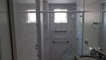Une salle de bain comprenant des toilettes, un lavabo et un espace douche.