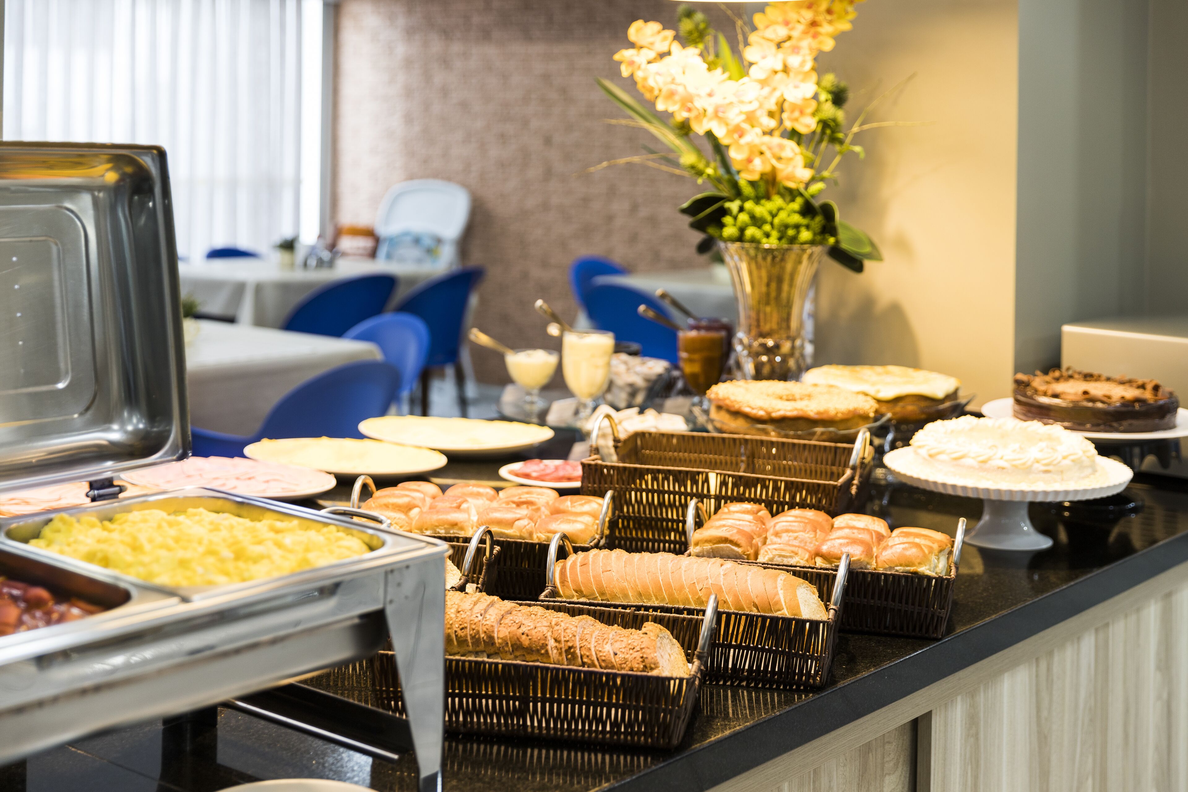 Un buffet proposant une variété de plats et un vase rempli de fleurs.