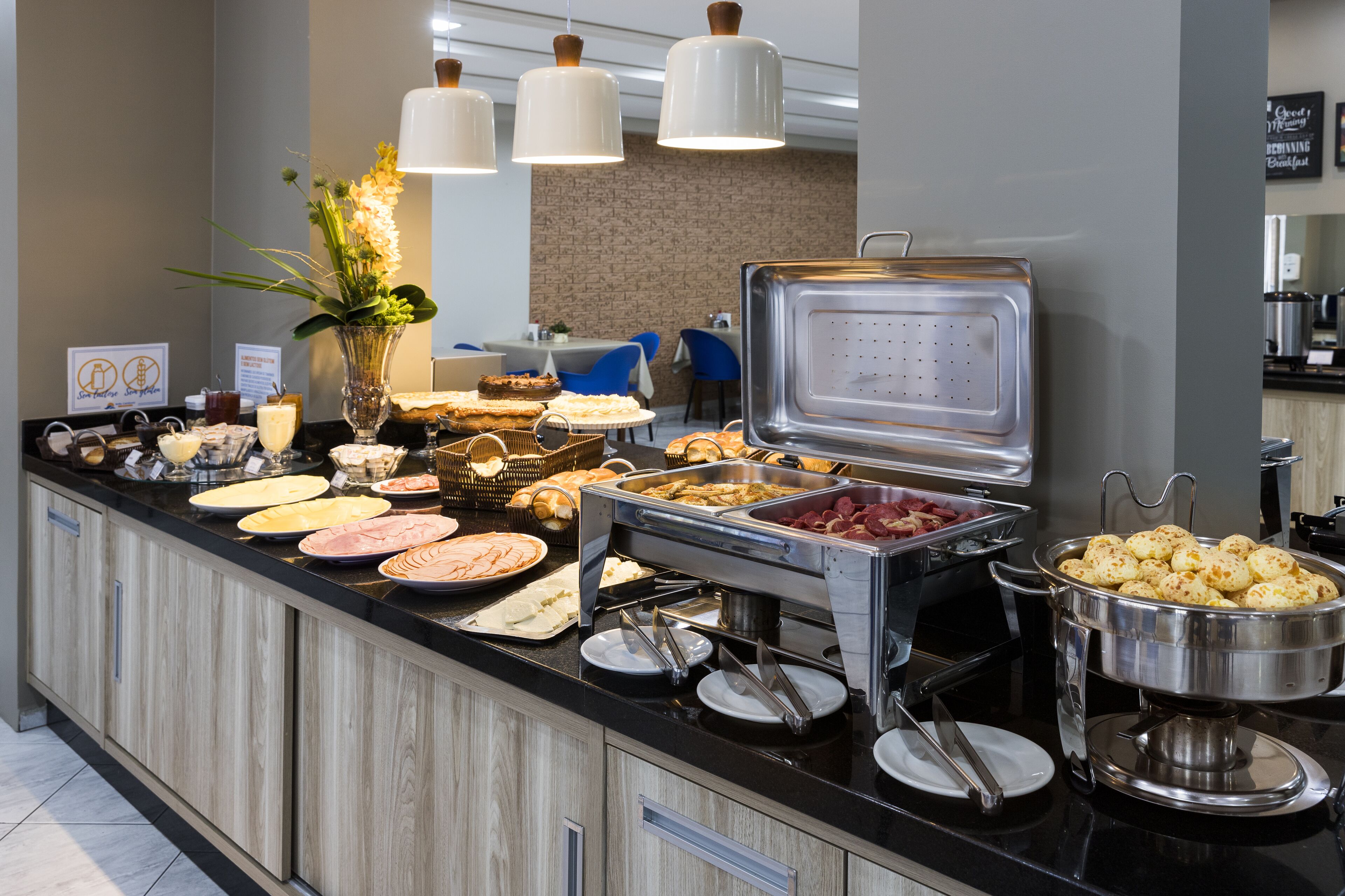 A buffet with various food items and a decorative plant.