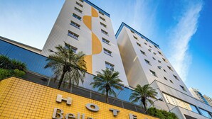 Ein Hotel mit auffälliger Beschilderung, moderner Fassade und blauem Himmel.