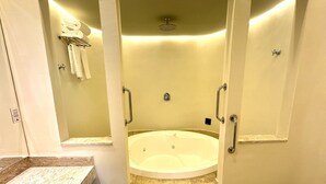 Un baño con lavamanos de mármol, inodoro y jacuzzi.