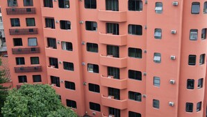 Un hotel de varios pisos con balcones y unidades de aire acondicionado.