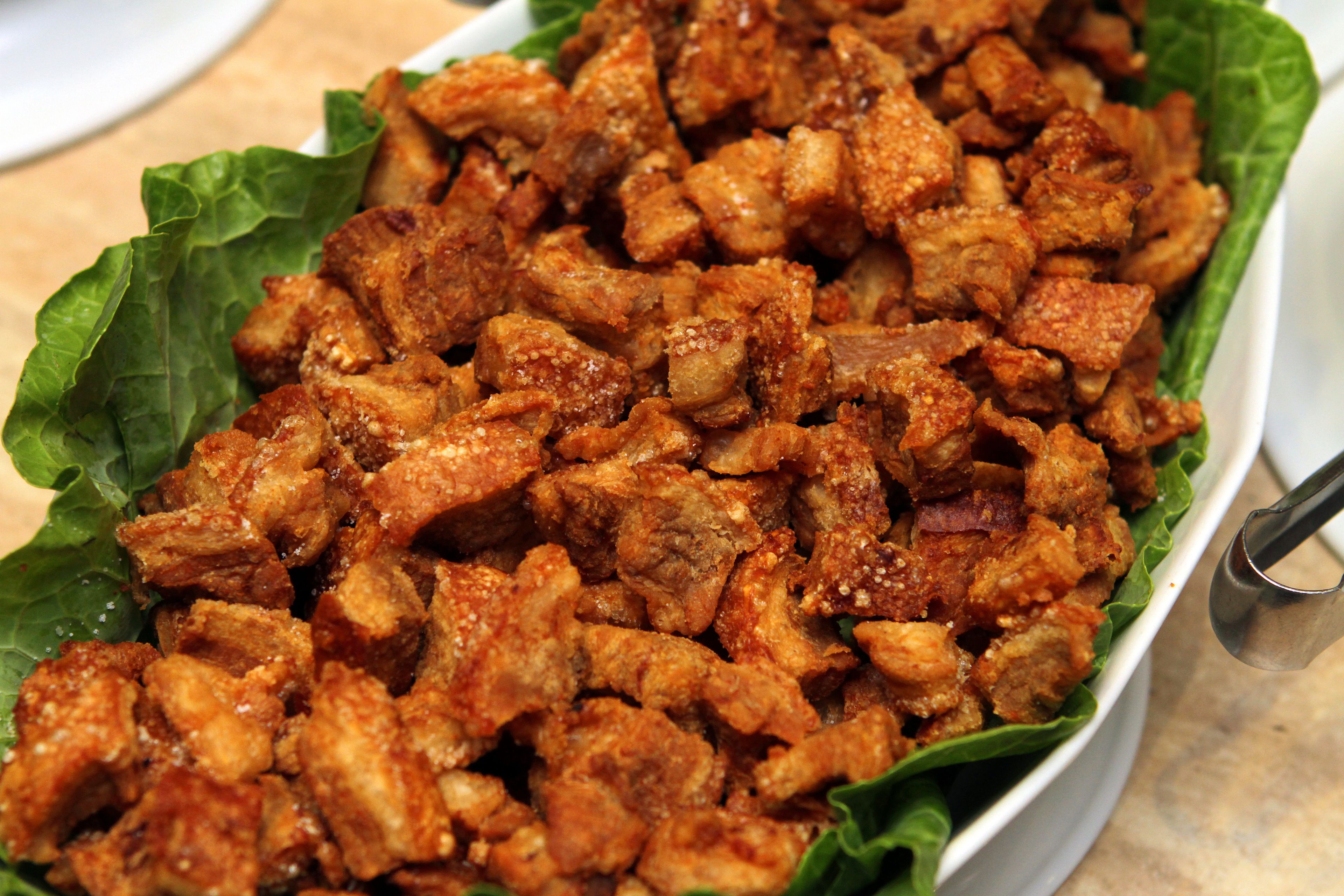A dish of fried pork pieces served on lettuce.