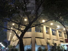 Un edificio moderno con ampie finestre e un albero di fronte.