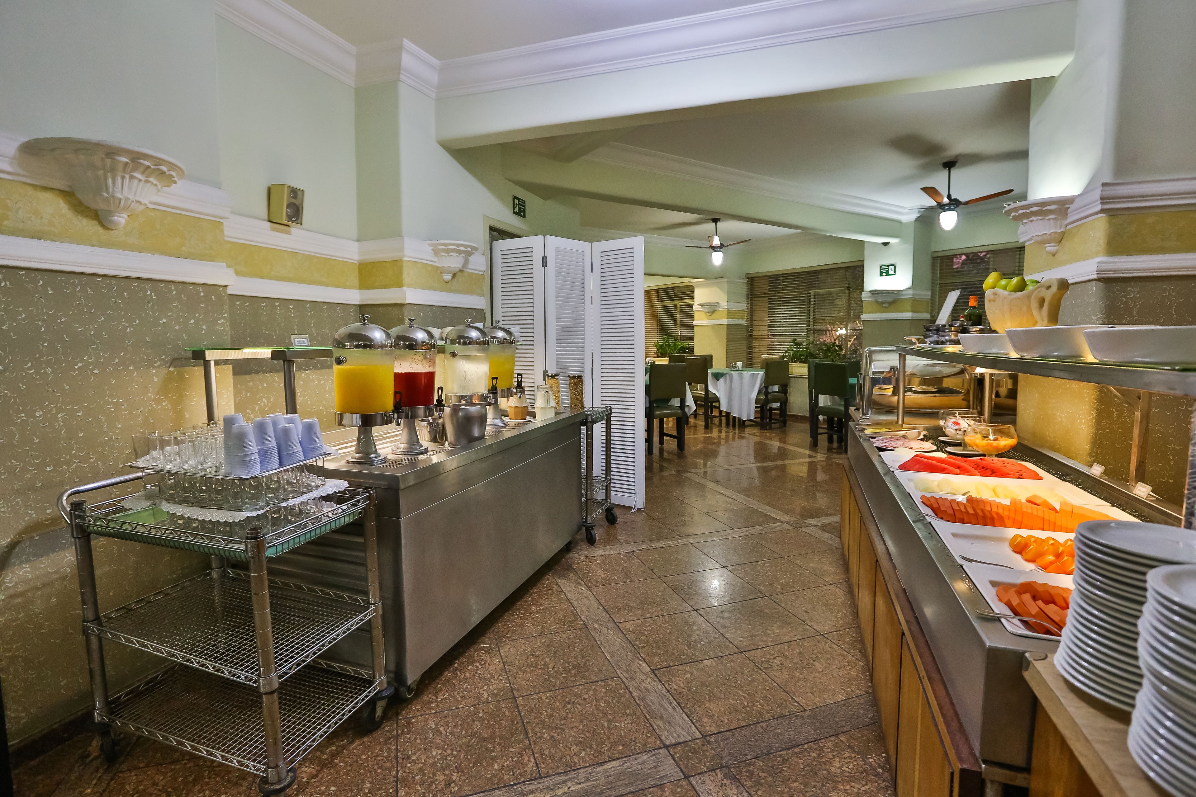 A buffet area with a variety of food options, a beverage station, and a seating area in the background.