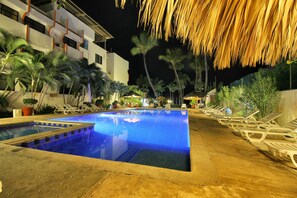 Piscina con tumbonas y palmeras.