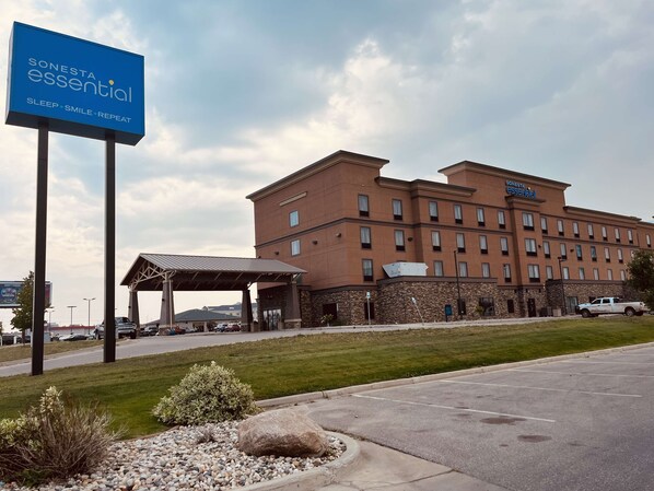 A Sonesta Essential hotel with a large sign, a covered entrance, and a parking lot.