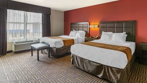 Quarto de hotel com duas camas, um banco, um aquecedor, uma janela com cortinas e uma parede vermelha.