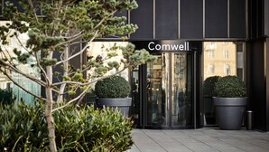 Een modern gebouw met een glazen ingang en de naam ‘Comwell’ erboven.