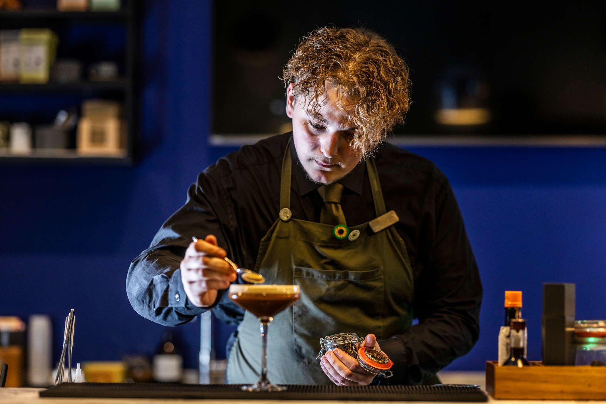 En bartender laver en drink bag baren.