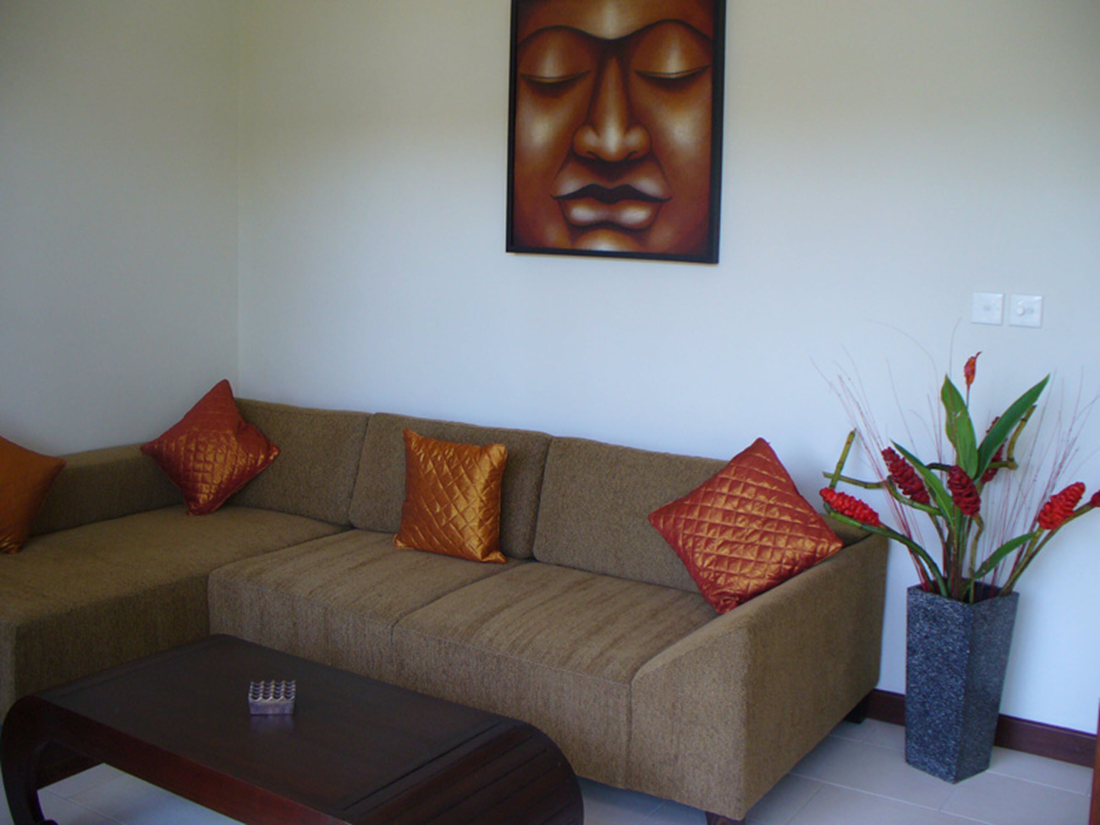 A living room with a sofa, a coffee table, and a decorative plant.