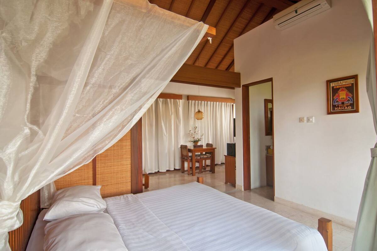 A bedroom with a bed, a desk, and a chair.