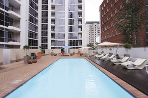 Utomhuspool, parasoller och solstolar