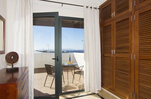 Un balcón con una mesa, sillas y vista al mar.