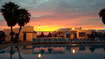 Una piscina al aire libre, tumbonas