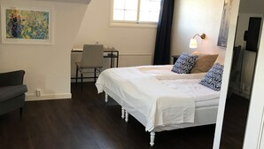 Un dormitorio con cama, escritorio, silla y sofá.