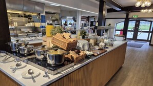 Una mesa de buffet con diversos alimentos y utensilios.