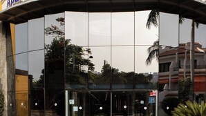 L’entrée de l’Aparthotel Villa de Adeje Beach se distingue par sa façade en verre et une enseigne incurvée placée au-dessus des portes.