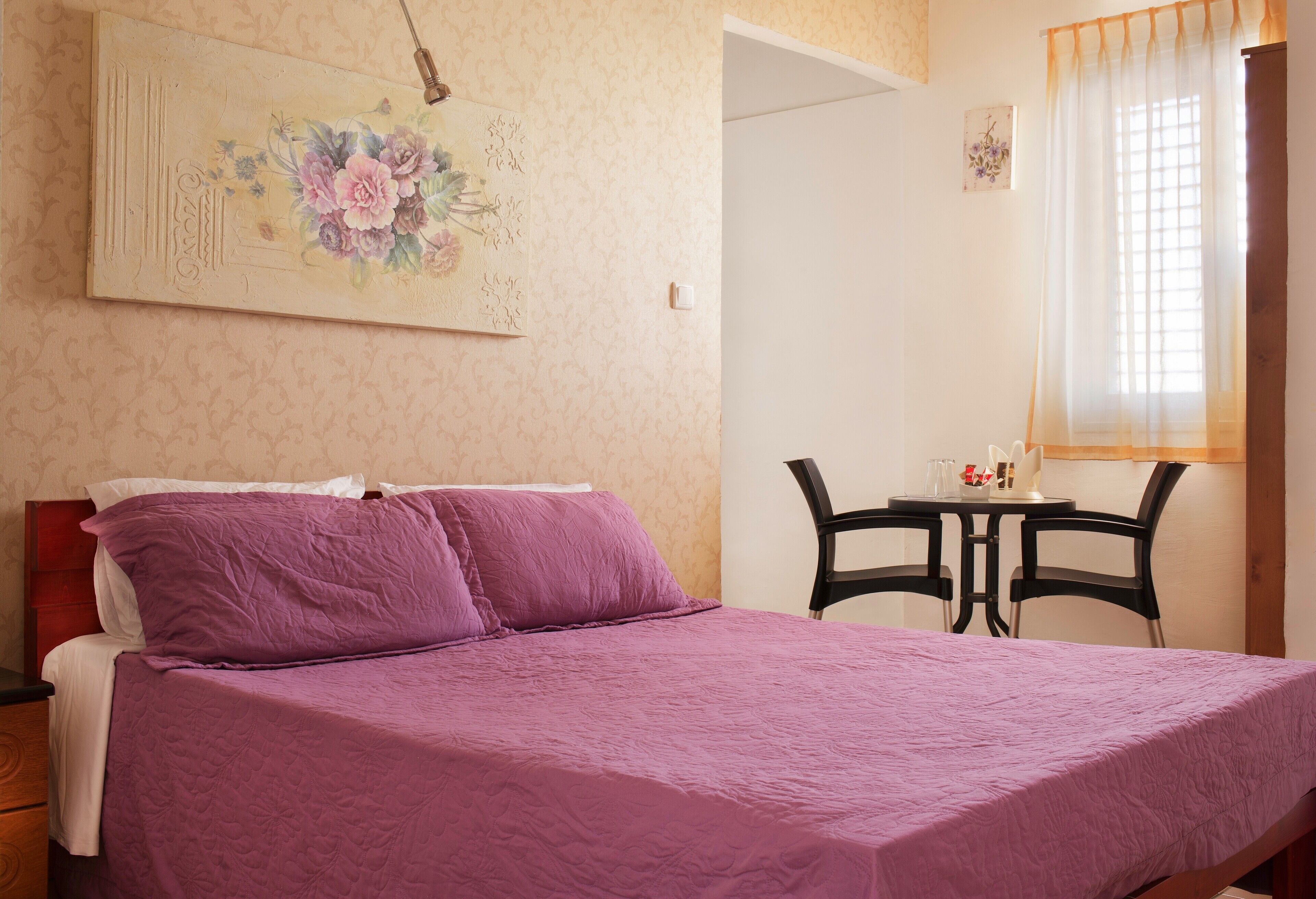 Un dormitorio con cama, escritorio y silla.