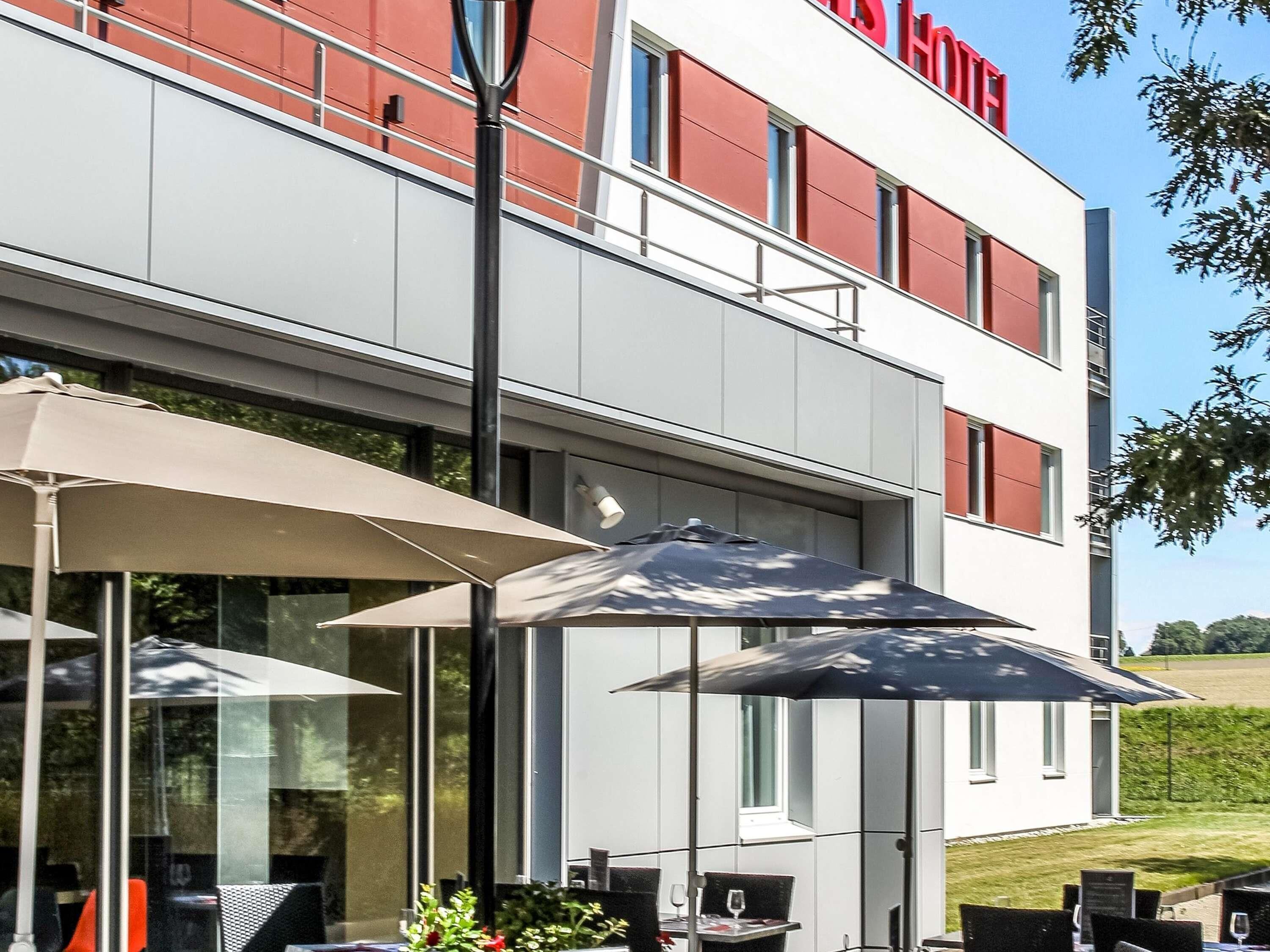 Un bâtiment moderne doté d’une terrasse et offrant une vue dégagée sur le paysage environnant.