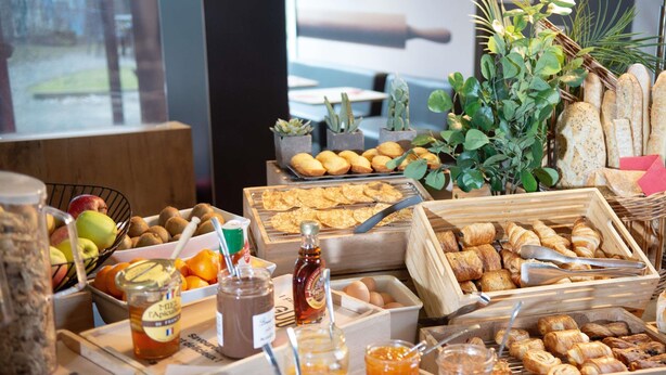 Een buffet met diverse soorten eten, waaronder fruit, gebak en sauzen.