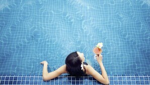 A person relaxing in a pool with a drink. - ibis Saint Genis Pouilly Genève (Saint-Genis-Pouilly)