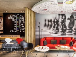 A modern lounge area with a chessboard, a red sofa, and a coffee table.