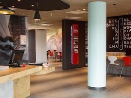 A modern reception area with a desk, chairs, and a large pillar.