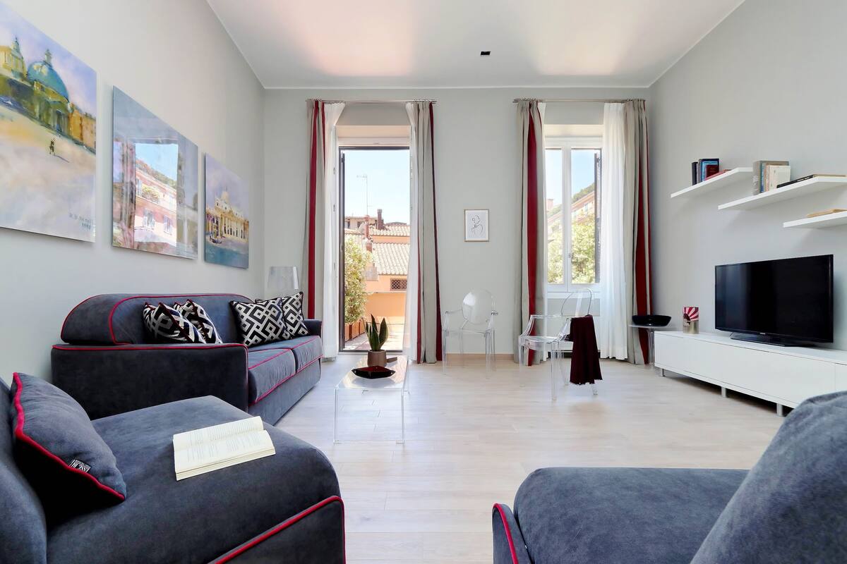 A modern living room with a sofa, a TV, and artwork on the wall.