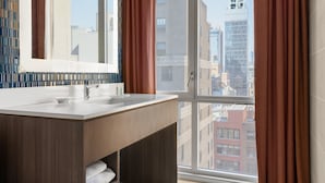 Een moderne badkamer met een groot raam, een spiegel en een wastafel.