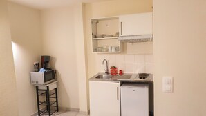 A compact kitchen with a microwave, sink, and small refrigerator. - Résidence d'Artagnan (Montargis)
