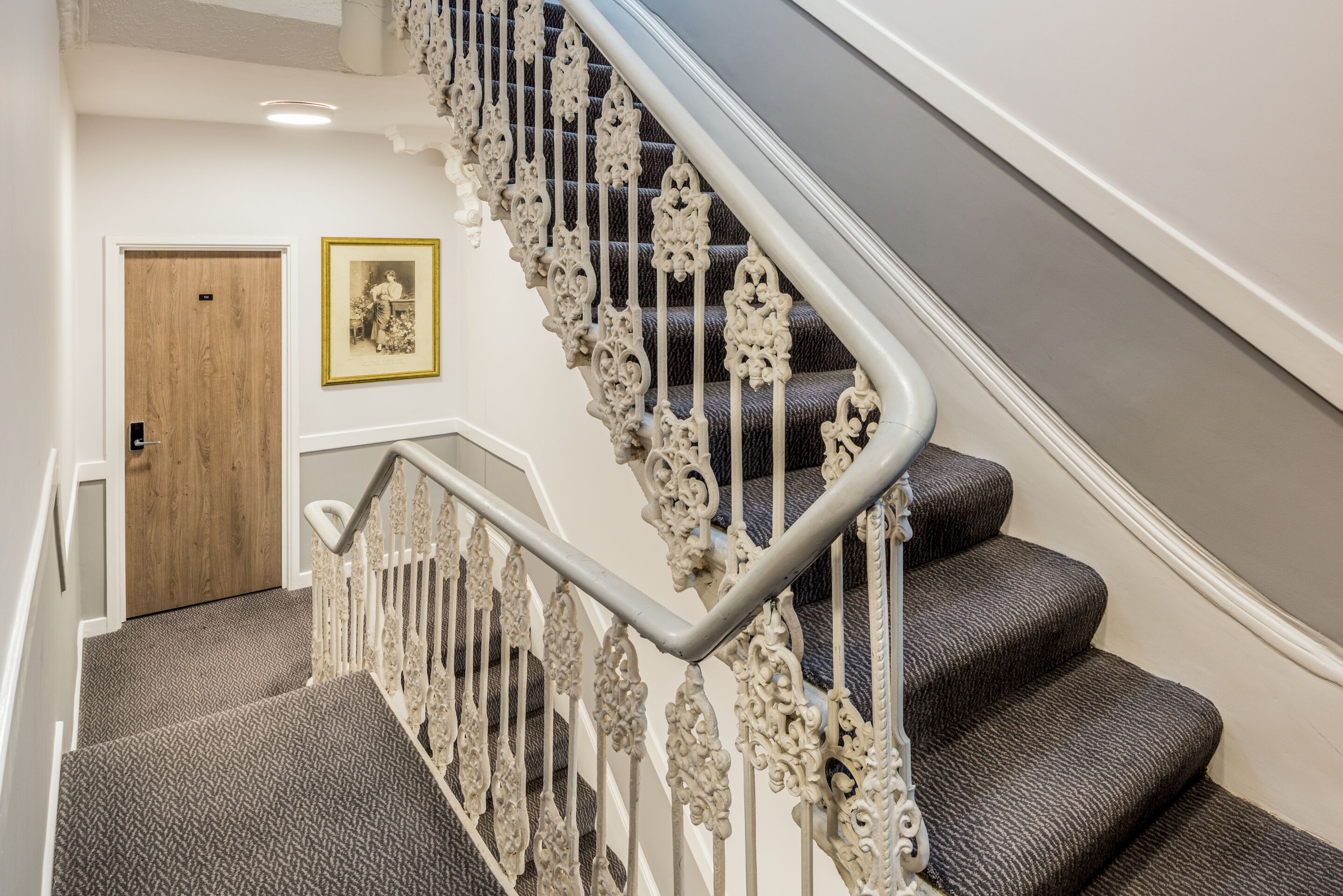 A staircase with ornate metal railings and carpeted steps.